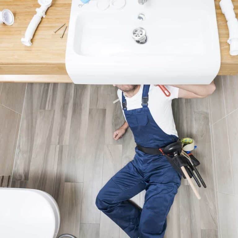 Sanitary technician working under a sink