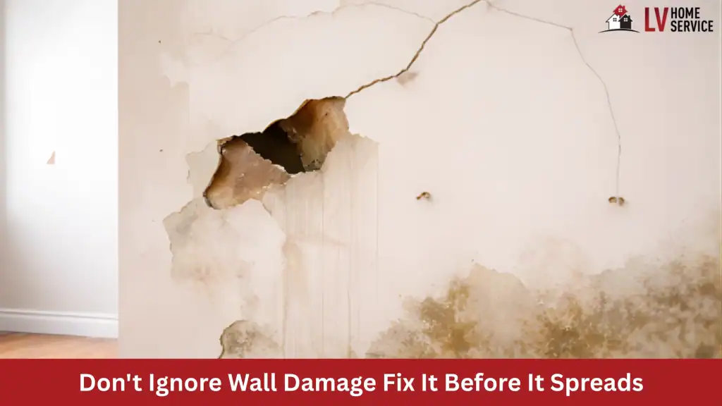 Damaged wall with cracks, hole, and moisture stains.